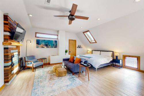 a bedroom with a bed and a couch and a tv at Stay Happy in Eureka Springs