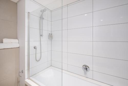 a bathroom with a shower with a glass door at Modern Two Bedroom Unit, Mountain & Harbour Views in Cape Town