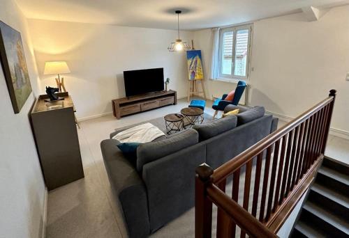 een woonkamer met een bank en een televisie bij Artist's Home - 65 m2 spacieux & confortable in Châlons-en-Champagne