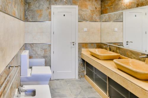 ein Badezimmer mit zwei Waschbecken und einem WC in der Unterkunft Falesia Beach A in Albufeira