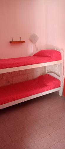1 dormitorio con 2 literas con sábanas rojas en Rawson Dpto Tornquist en Tornquist