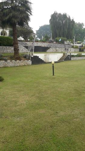 a giraffe standing in a field next to a bridge at Kigezi Gardens Inn in Kabale