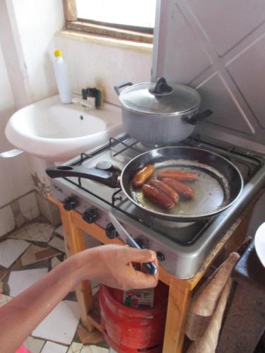 a frying pan on a stove in a kitchen at Simba Apartments in Diani Beach