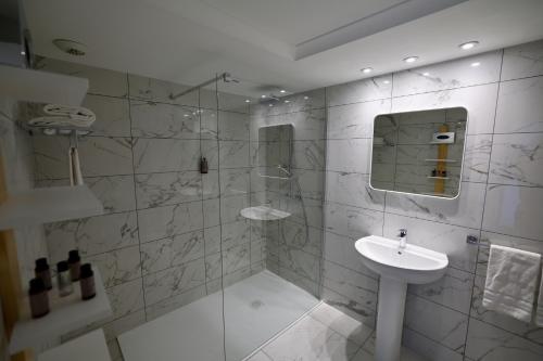 a white bathroom with a shower and a sink at Résidence Carlton - Rénovée avec Piscine in Beaulieu-sur-Mer