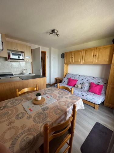 Cette chambre comprend une table et un lit avec des oreillers roses. dans l'établissement Thollon-les-Mémises - IGLOO 1, à Thollon-les-Mémises