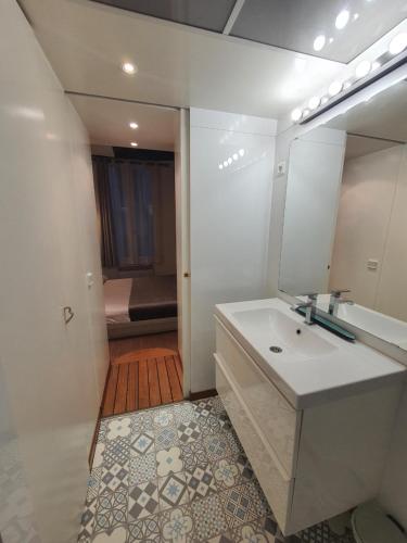 une salle de bain avec un lavabo et un miroir dans l'établissement Couleur St Martin, à Paris