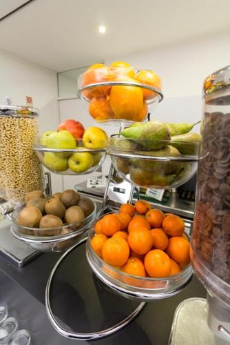a bunch of bowls of fruit on a counter at Hotel Laranjeira in Viana do Castelo