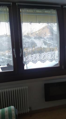a window with a view of a snow covered field at CASA DESIRE' in Piancavallo