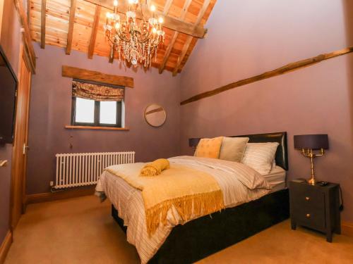 a bedroom with a bed and a chandelier at Oak Barn in Sandbach