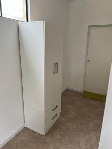un armario blanco en una habitación con puerta en Departamento guemes C en San Pedro