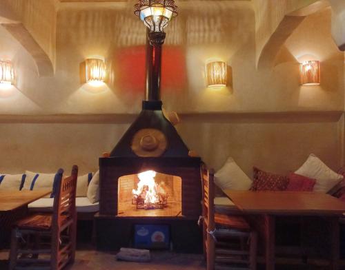 een open haard in een kamer met een tafel en stoelen bij Riad Sabah in Marrakesh