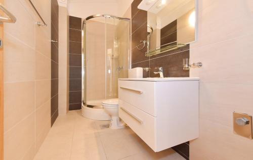 biała łazienka z umywalką i toaletą w obiekcie APARTMANI SABB w mieście Jezera