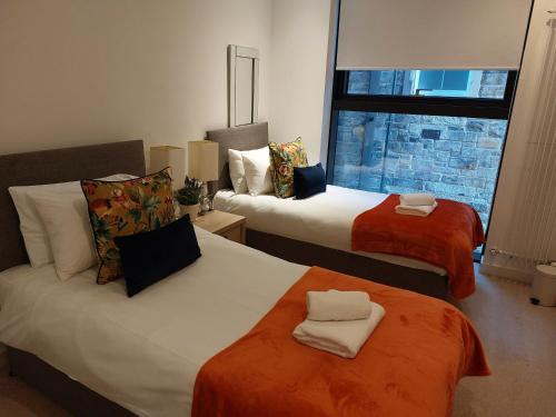 Habitación de hotel con 2 camas y ventana en Quartermile Luxury Landing Apartment, en Edimburgo