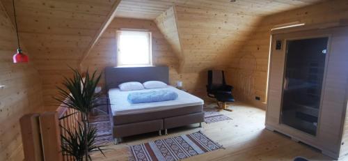 a bedroom with a bed in a wooden cabin at Vila Vilinka & Vila Native Vilinija resort Village in Podčetrtek