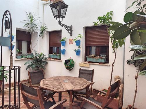eine Terrasse mit einem Holztisch, Stühlen und Pflanzen in der Unterkunft La Casa de Pedro Verdugo Apartamento Turístico in Córdoba