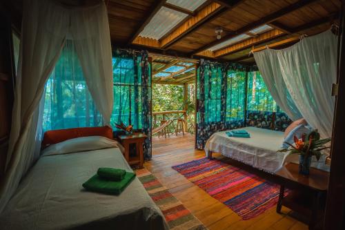 a bedroom with a bed and a table in a room at Ocean Forest Ecolodge in San Pedrillo