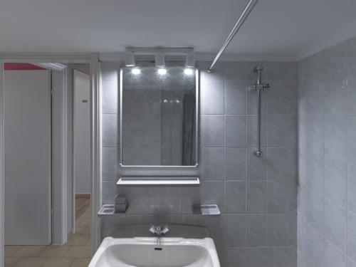 łazienka z umywalką i lustrem w obiekcie 2 bedroom apartment close to children's hospital w Atenach