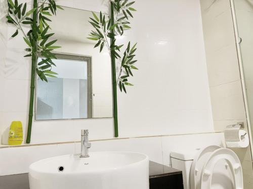 La salle de bains blanche est pourvue d'un lavabo et d'un miroir. dans l'établissement JB City 1 Tebrau T19 1BR by GreatDay, à Johor Bahru