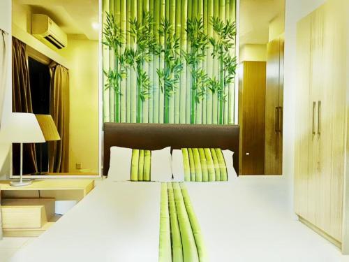 - une chambre avec un grand lit et un mur vert dans l'établissement JB City 1 Tebrau T19 1BR by GreatDay, à Johor Bahru