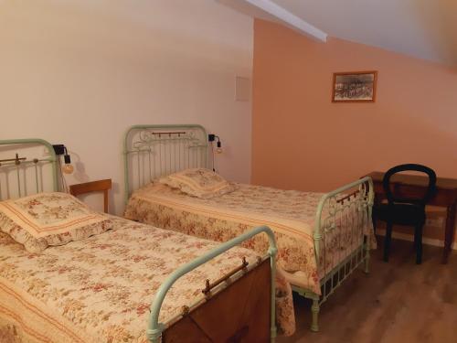 une chambre avec deux lits et une chaise dans l'établissement Gîte 