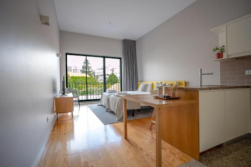 波多的住宿－Oporto Trendy Formosa，厨房以及带桌子和沙发的客厅。