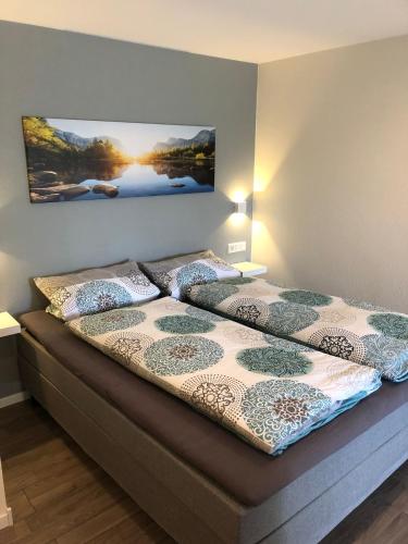 a bedroom with a bed with a picture on the wall at Ferienwohnung Maldener in Namborn