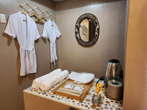 een badkamer met een aanrecht met handdoeken en een spiegel bij Casa de Cortijo in Pagbilao