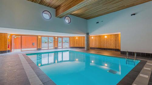 - une grande piscine d'eau bleue dans une maison dans l'établissement Madame Vacances Les Epinettes, à Vaujany