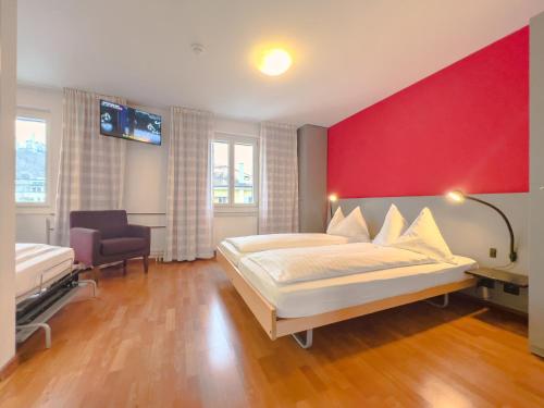 ein Schlafzimmer mit einem großen Bett und einer roten Wand in der Unterkunft Hotel Rothaus Luzern & Peruvian Culinary Art in Luzern