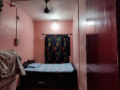 a small room with a bed and a curtain at 2BHK Flat Available for Wedding Guests, Home stay, Travelers - Mumbra in Thane