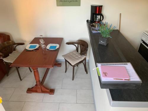 a small kitchen with a wooden table and chairs at Les Gîtes de la Colo in Ravenoville