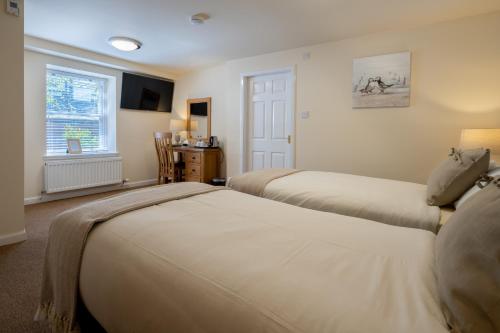 a bedroom with two beds and a window at The Waterfront in Anstruther
