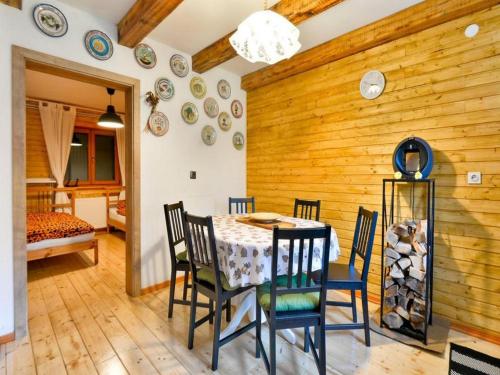 a dining room with a table and chairs and a bedroom at Holiday Home Nada in Partizanska Drežnica