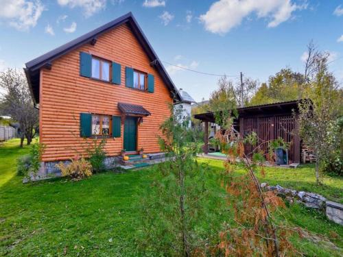 una casa arancione con una porta verde e un cortile di Holiday Home Nada a Partizanska Drežnica
