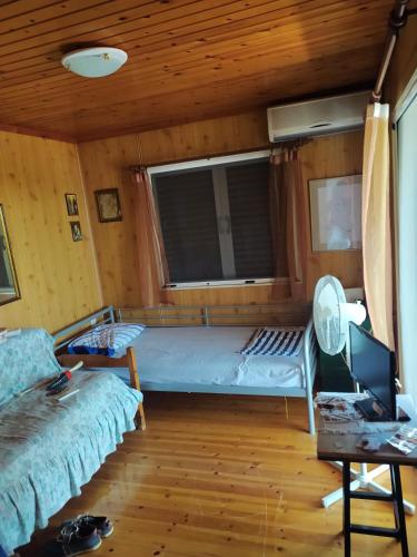 a room with a bed and a desk with a laptop at σπίτι - αγρόκτημα - Δ Γεωργά Χατζηράση οδός Χατζηράση in Porto Heli