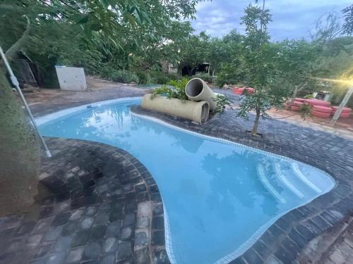 a large blue swimming pool in a yard at Klein Paradys Lodge - Polokwane in Polokwane