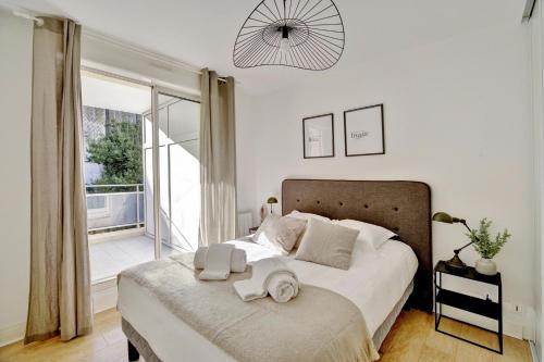 une chambre avec un grand lit avec des serviettes dessus dans l'établissement Le Bienheureux Beau T2 en plein centre avec grande Terrasse, à Bordeaux