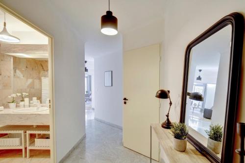 une salle de bain avec un miroir et un lavabo dans l'établissement Le Bienheureux Beau T2 en plein centre avec grande Terrasse, à Bordeaux