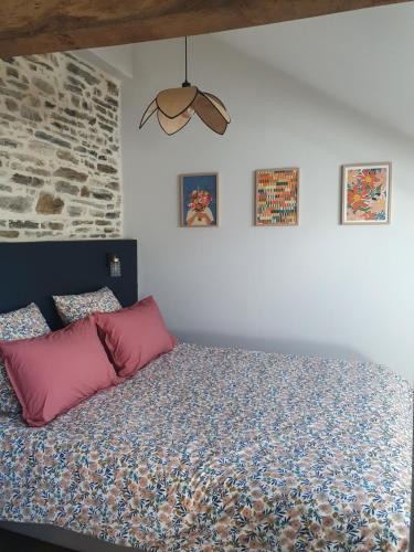 a bedroom with a bed and a brick wall at Gîte des Lavandières in Amanlis