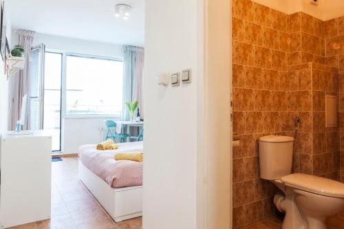a bathroom with a toilet and a shower and a bedroom at Tony's Sunny Rooftop Studio in Sofia