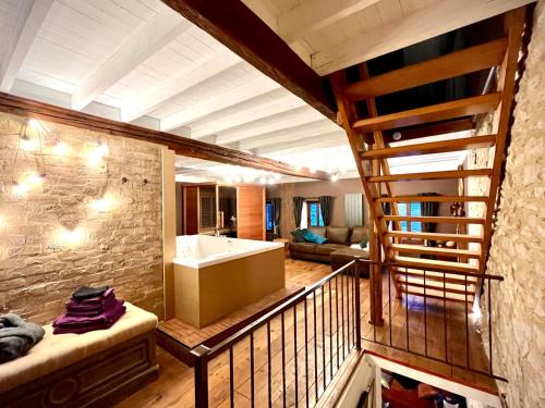 een kamer met een balkon, een wastafel en een bank bij Le Secret de Mélin in Mélin