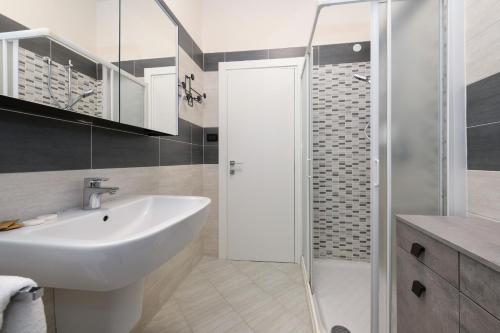 My Desenzano Family Apartment في ديسينسانو ديل غاردا: حمام مع حوض ودش