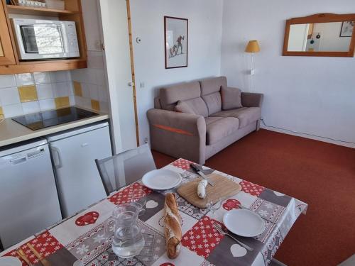 un salon avec une table et un canapé dans l'établissement Studio pratique proche pistes avec terrasse et animaux admis - FR-1-181-2227, à La Plagne Tarentaise