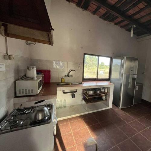 a kitchen with a stove and a refrigerator at Uruguay Casa de Época Campestre in Mercedes