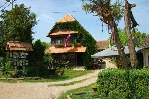 Mužilovčica的住宿－拉夫里克鄉村旅遊家庭旅館，前面有标志的小建筑