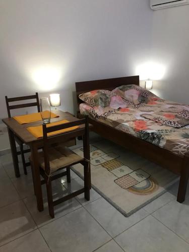 1 dormitorio con 1 cama, 1 mesa y 1 silla en Appartement T1, en Saint-Laurent-du-Maroni