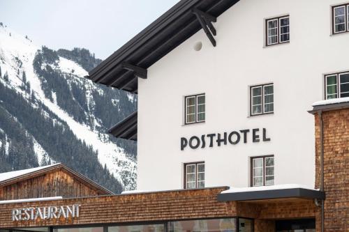 a sign on the side of a hotel with mountains in the background at Posthotel Lechtal, Arlberg in Holzgau