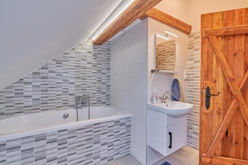 a bathroom with a bath tub and a sink at Agroturystyka Sòjkowy Zakątek in Dzierżążno Małe