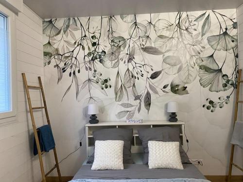 a bedroom with a desk with a flower mural on the wall at Charmant petit appartement les pieds dans l'eau in Douarnenez