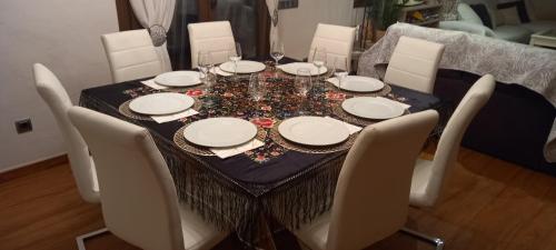a dining room table with white plates and chairs at Villa Alba cerca de Sitges in Canyelles